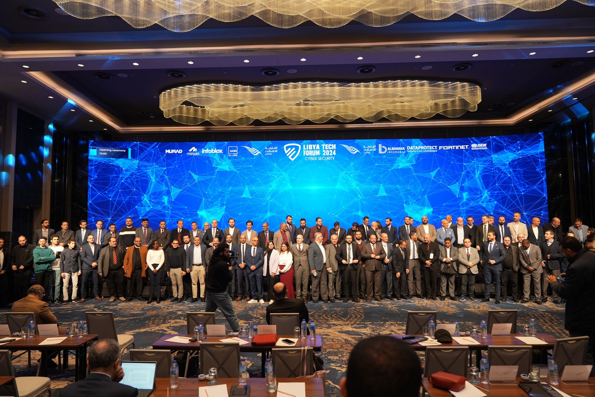 Group photo of attendees on stage in front of the LED wall