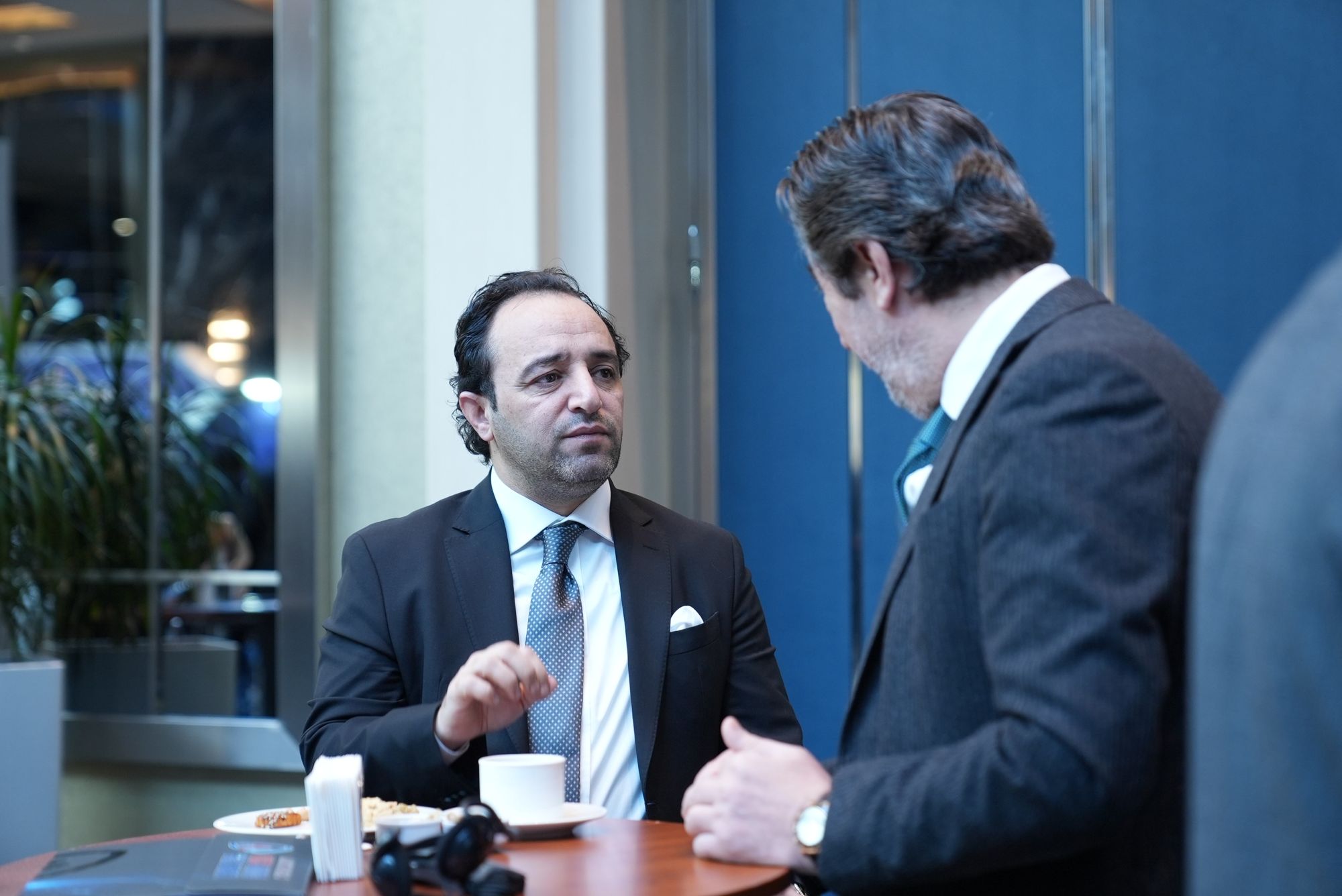 Two guests in conversation during a coffee break